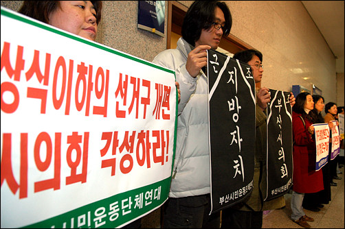 한 시민단체 회원이 '상식이하의 선거구제 개편'을 규탄하는 플래카드를 펼쳐보이고 있다. 